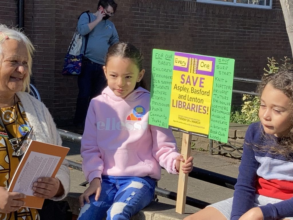 A young girl at an Aspley Library read-in protest, holding a Save Our Libraries placard. 