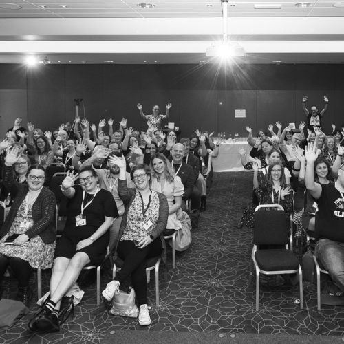 A black and white photograph of CILIPS members cheering at the 2022 CILIPS Annual Conference.