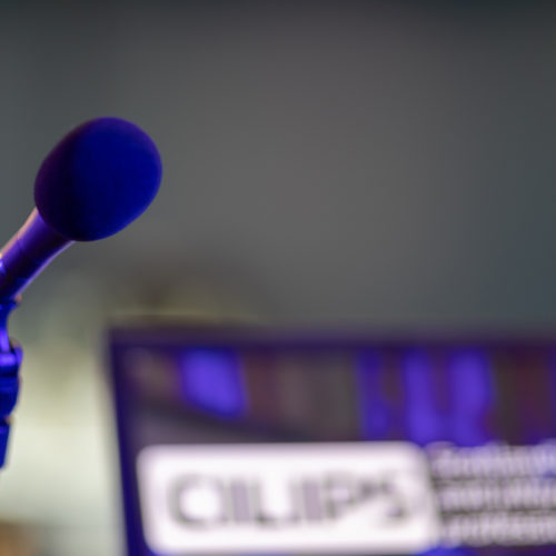 A microphone beside a laptop with the CILIPS logo showing.