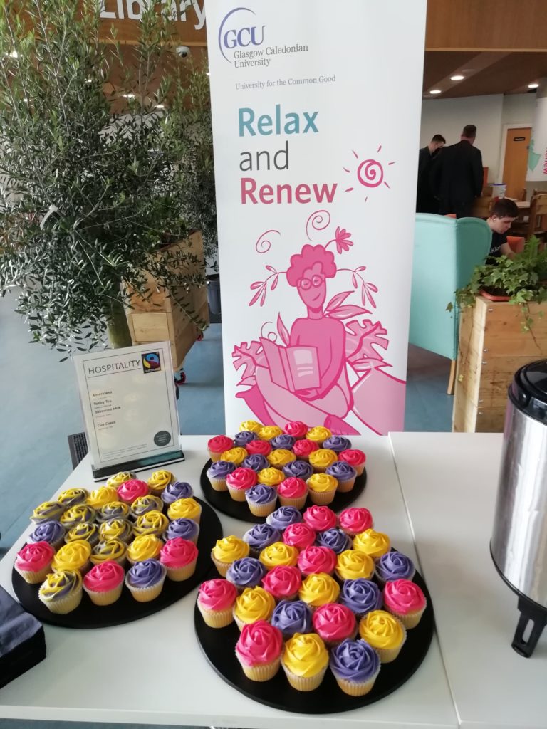 Plates of cupcakes in front of a banner for Relax and Renew: the new Wellbeing space within the Sir Alex Ferguson Library at Glasgow Caledonian University
