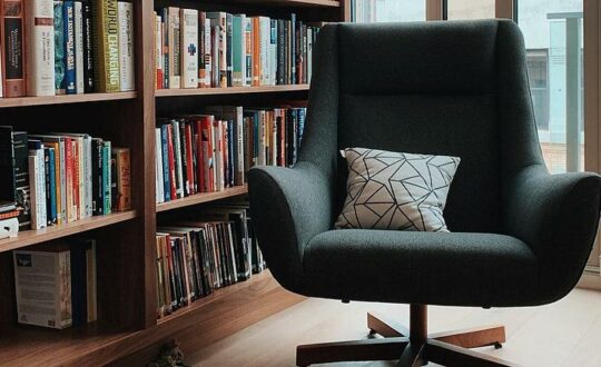 A library nook with bookshelves and a comfy reading chair.