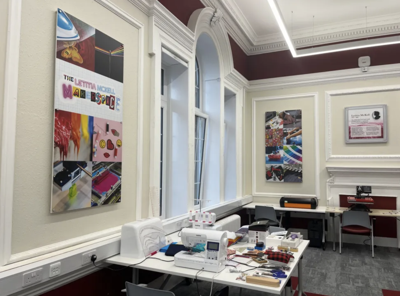 Image shows a photograph of the Letitia McKell makerspace in Motherwell Library. It's a white room with big victorian windows, a sign with the space's name and a table with crafts and a sewing machine. 