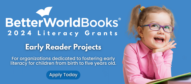 Better World Books 2024 Literacy Grants for Early Reader Projects. Showing a young girl smiling whilst reading a book.