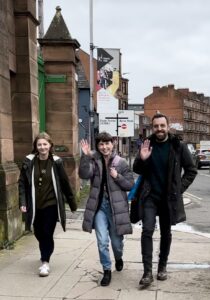 Leah, Kirsten and Sean from CILIPS waving as they walk along the road.